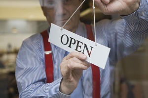 man turning open sign